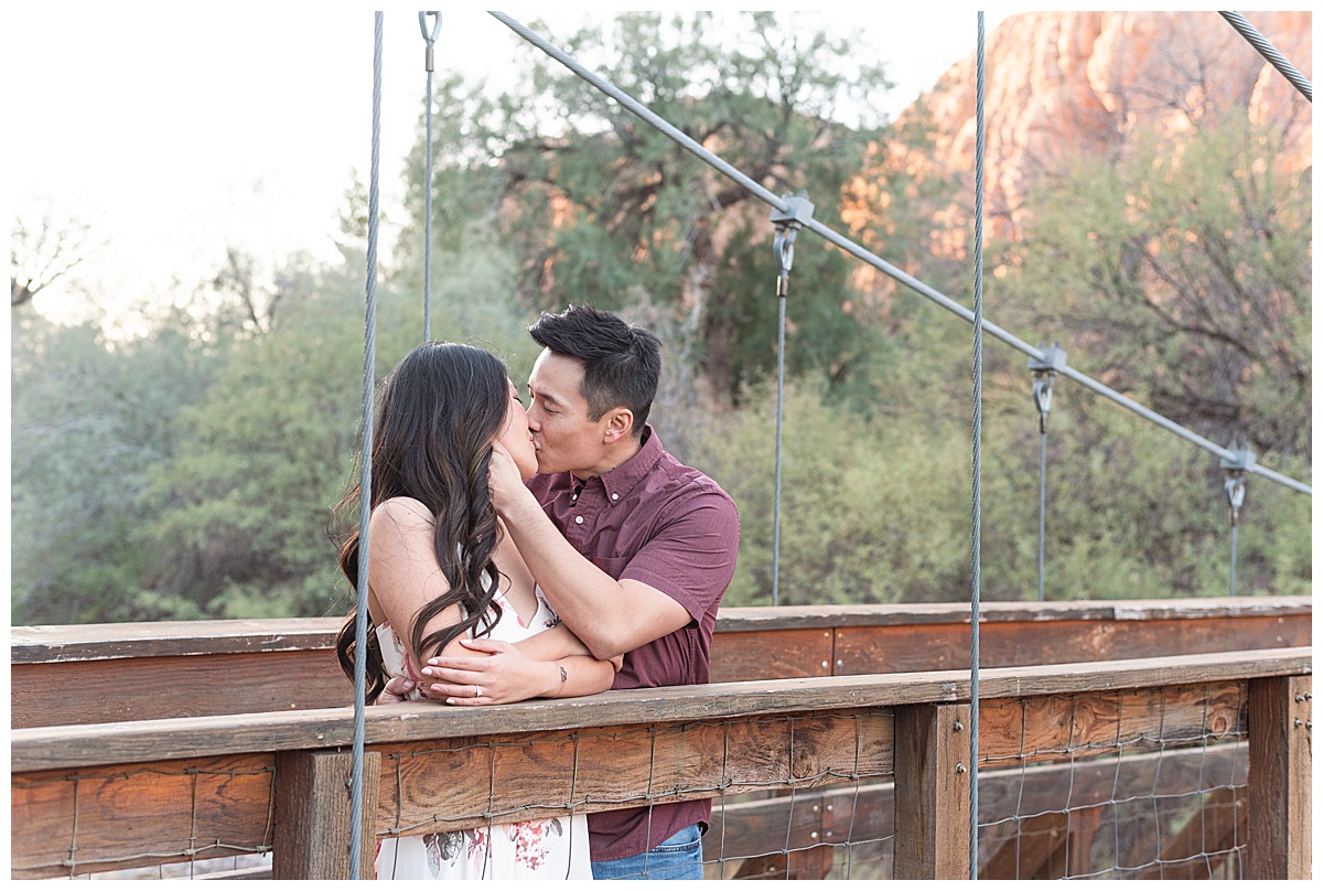man kissing wife on bridge