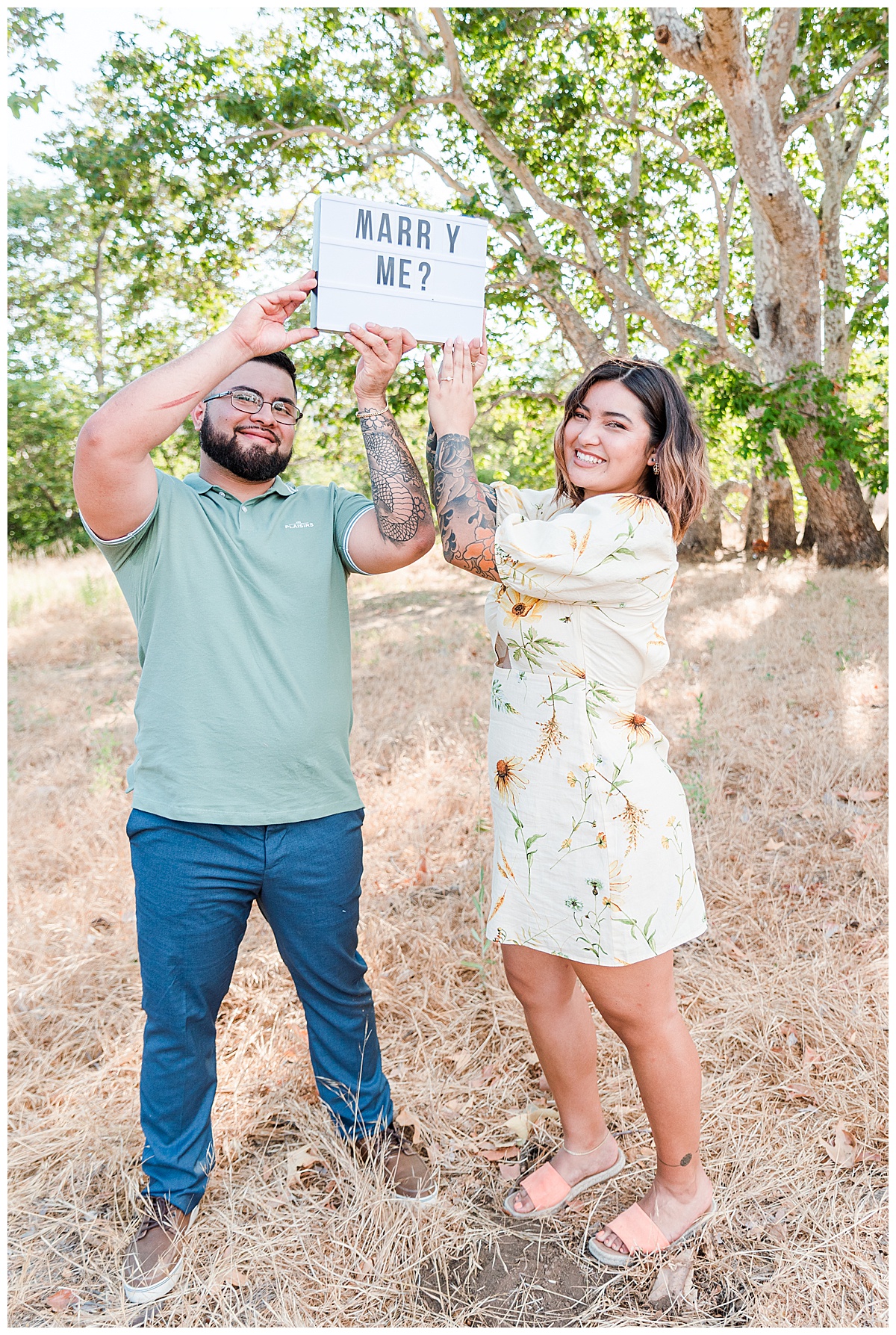 couple holding up marry me sign